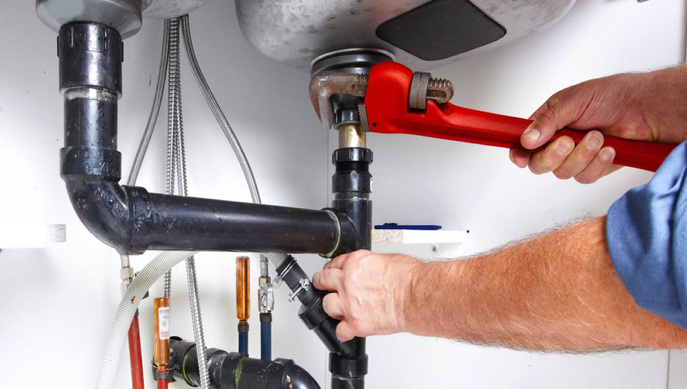 A plumber adjusting under sink connections